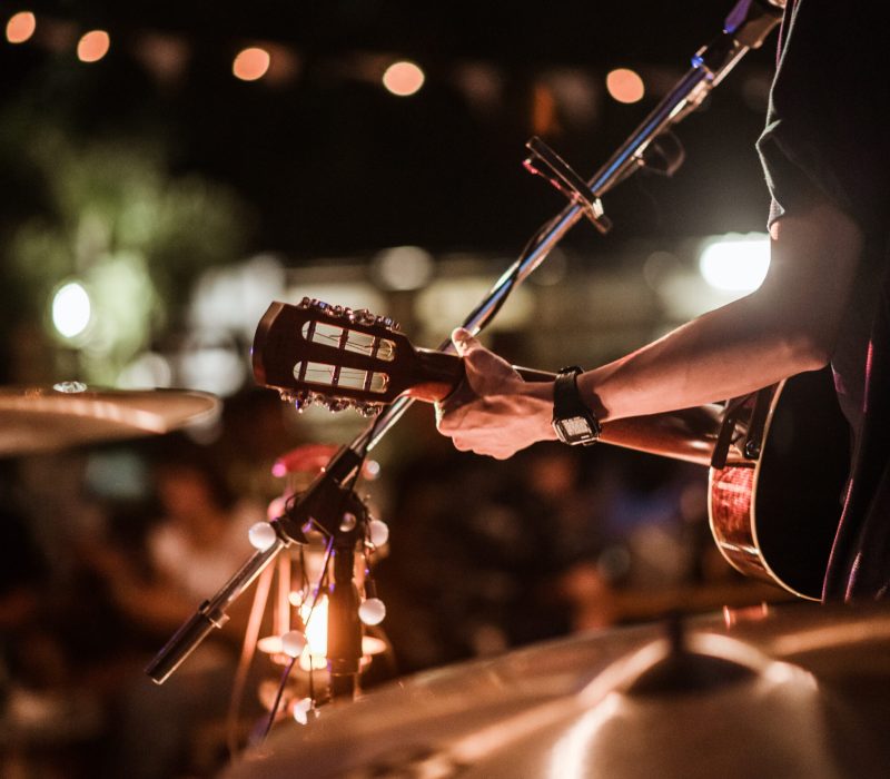 The musicians were playing rock music on stage, there was an audience full of people watching the concert. Concert,mini concert and music festivals.