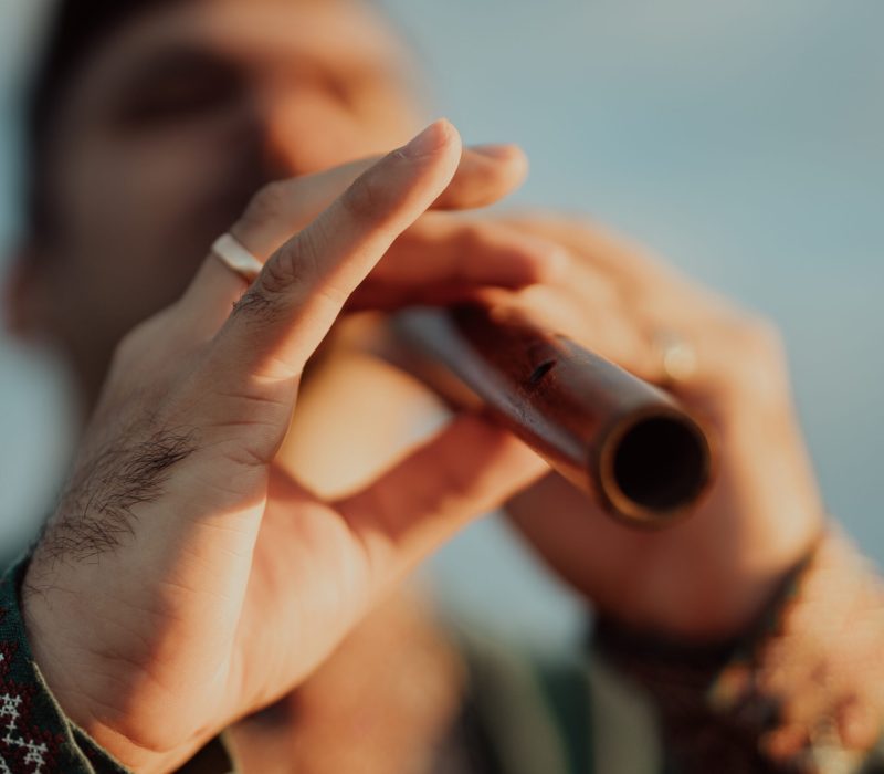 Young man playing on woodwind wooden flute - ukrainian sopilka